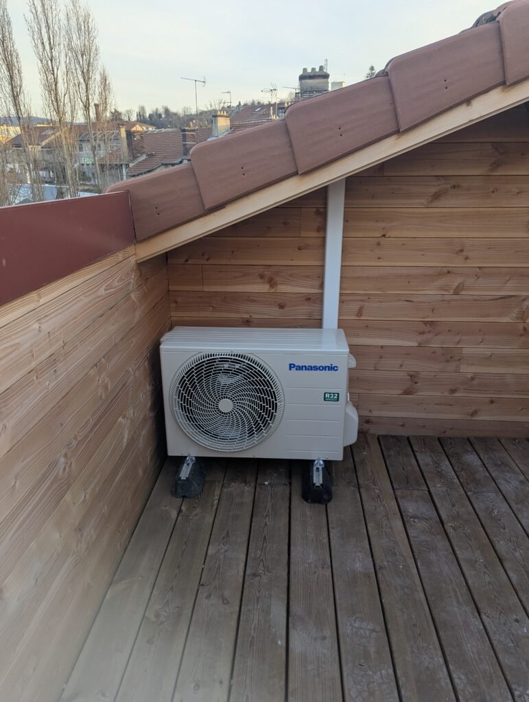 Groupe extérieur de climatisation posé sur une terrasse en bois